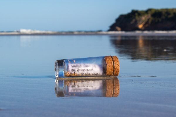 a message in a bottle sitting on the beach