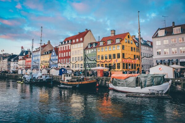 Boats moored along the canal in front of colorful buildings in Nyhavn, Copenhagen
