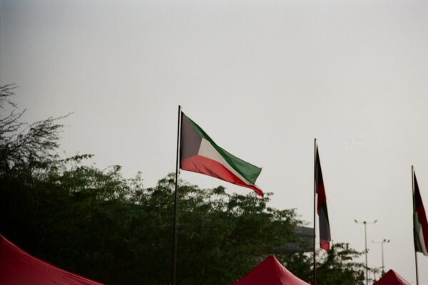 Kuwaiti flag waving against a cloudy sky