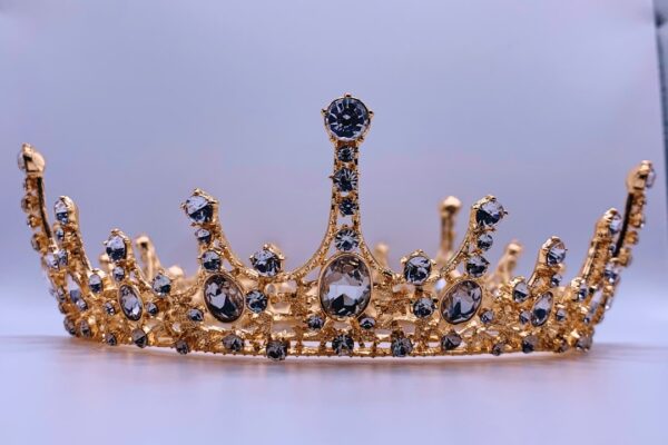 a gold crown with black and white stones
