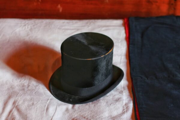black top hat on white textile